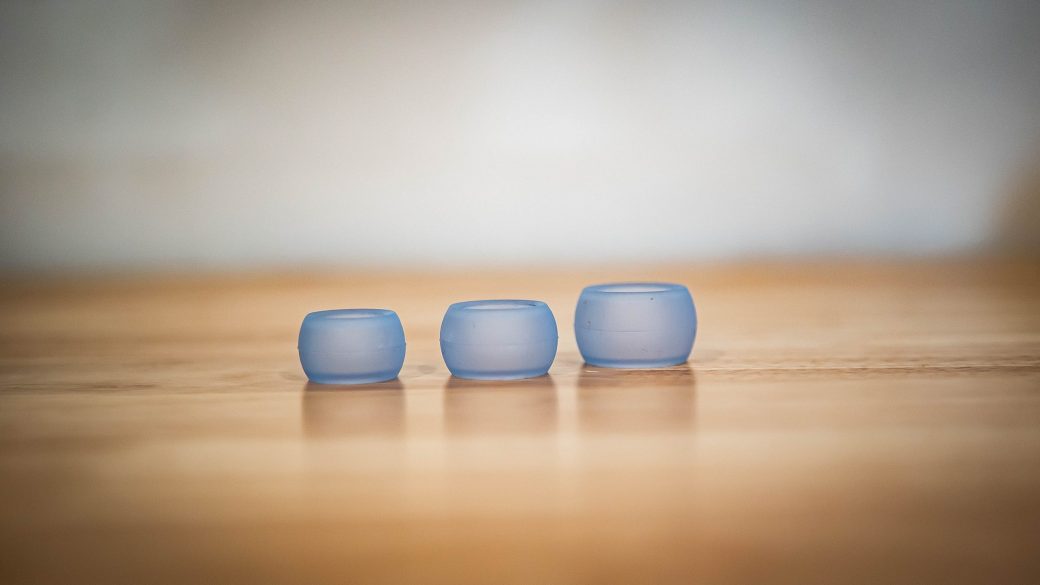 Three Ring Wrapper silicone ring covers in Azure, in small, medium and large, lined up on a wooden table