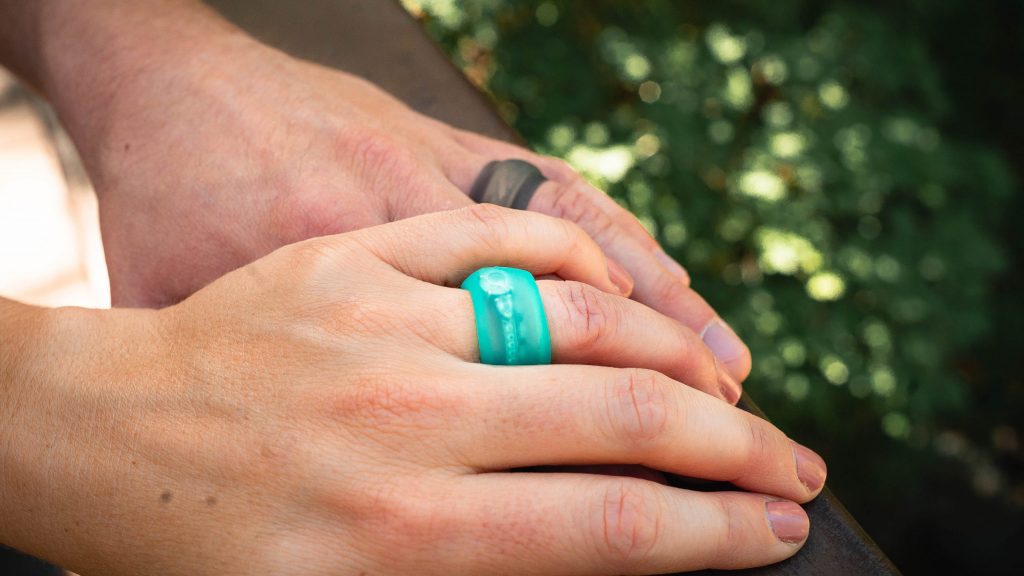 A couple wearing silicone Ring Wrapper covers over their wedding bands